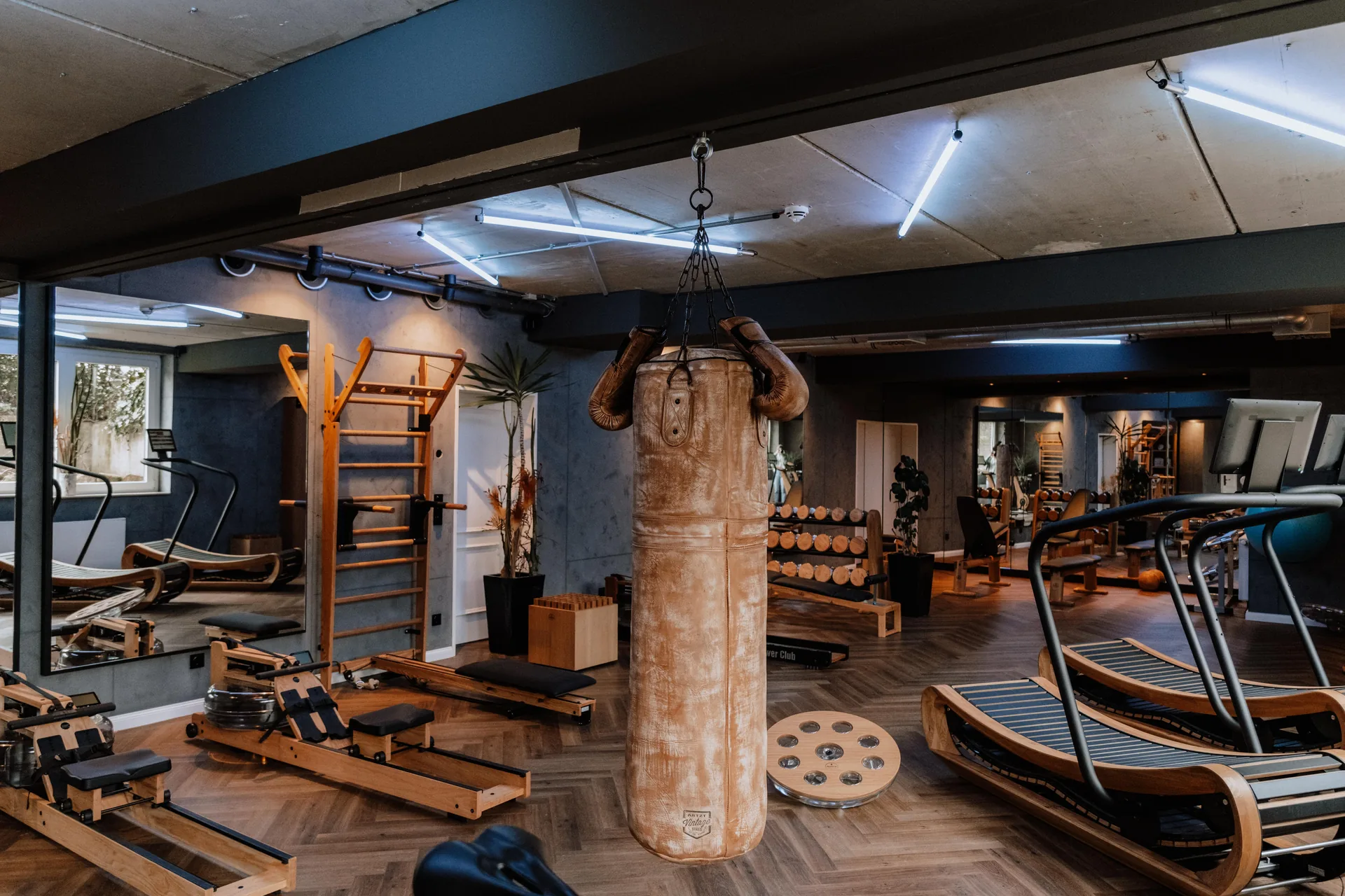 Leren bokszak met vintage bokshandschoenen in een boxing corner.